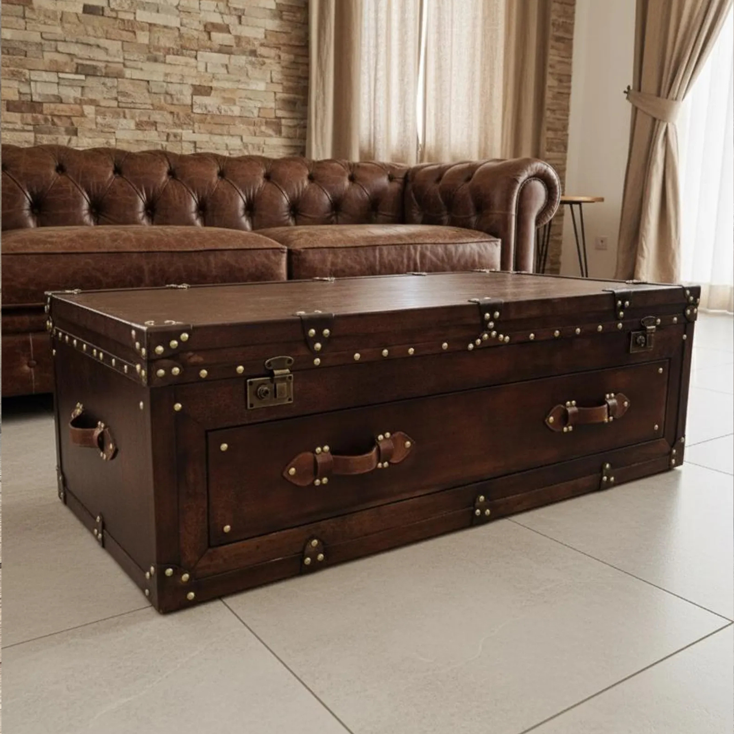 Wooden trunk used as a coffee table in a living room with a brown sofa and curtains.