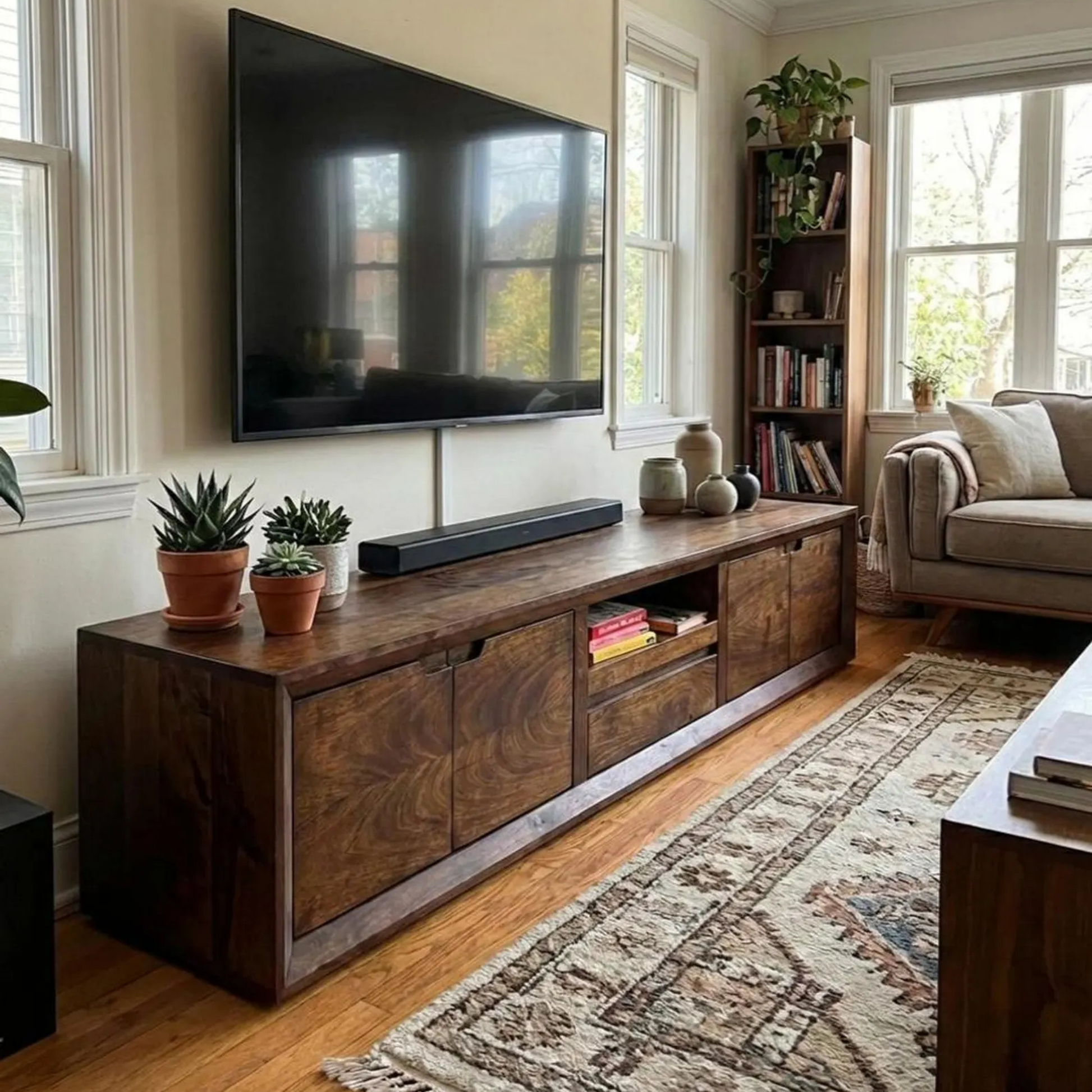 Living room with wooden TV stand, television, and decor
