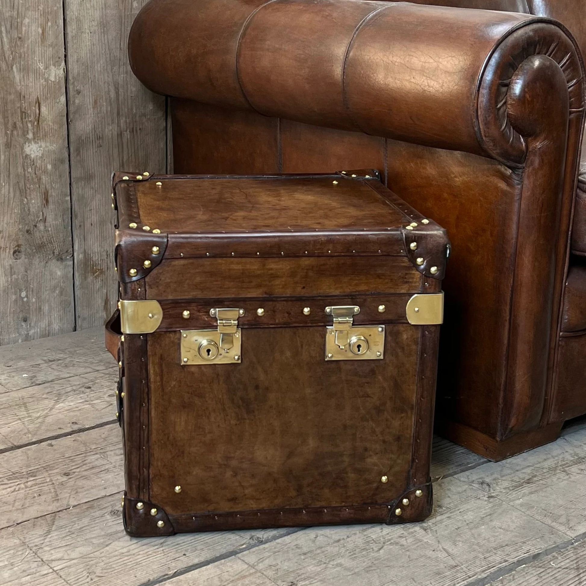 Handmade leather side table trunk showing internal storage compartment
