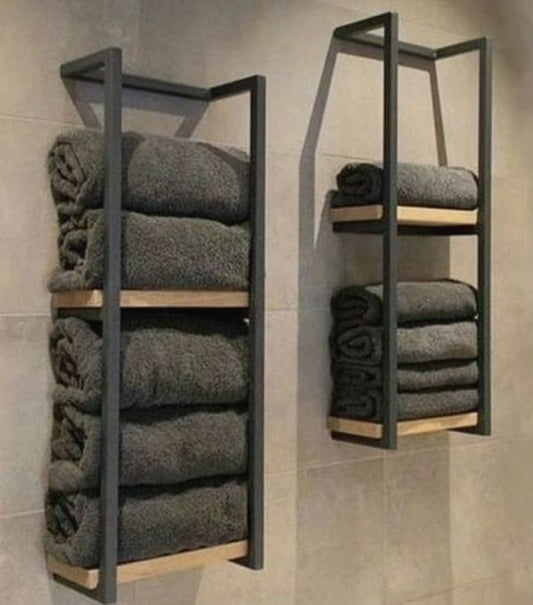 Towel racks with folded towels against a tiled wall.