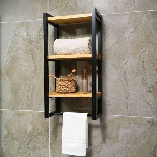 Wooden shelf with black frame mounted on a tiled wall, holding towels and decorative items.