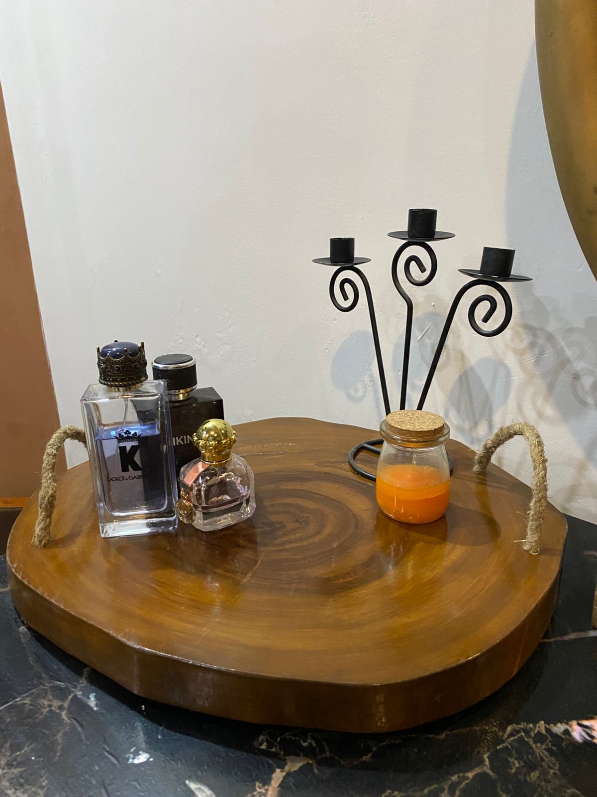Decorative setup with bottles, a candle holder, and a jar on a wooden surface.