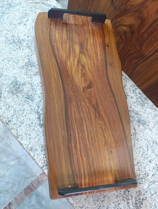 Wooden tray with black handles on a stone surface.