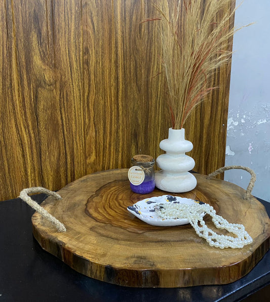 Wooden tray with decorative items including a candle, small dish, and vase against a wooden background.