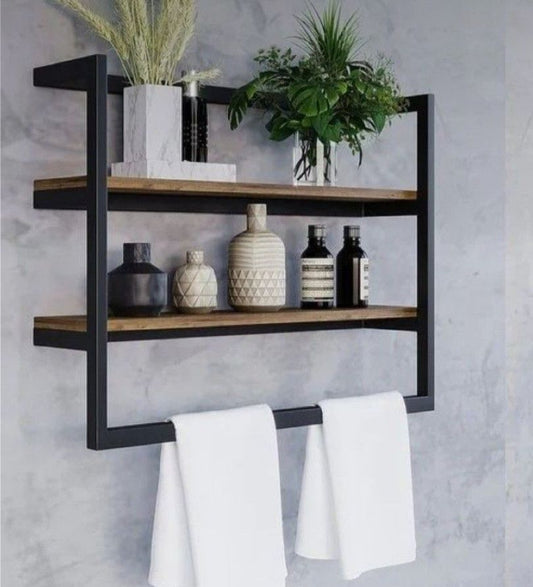 Wall-mounted shelf with wooden shelves and metal brackets, holding decorative items and towels.