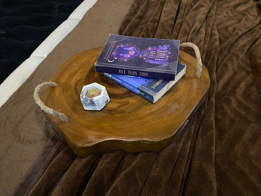 Wooden tray with books and a crystal on a brown textured surface