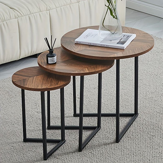 Set of three wooden side tables with black metal legs in a living room setting.