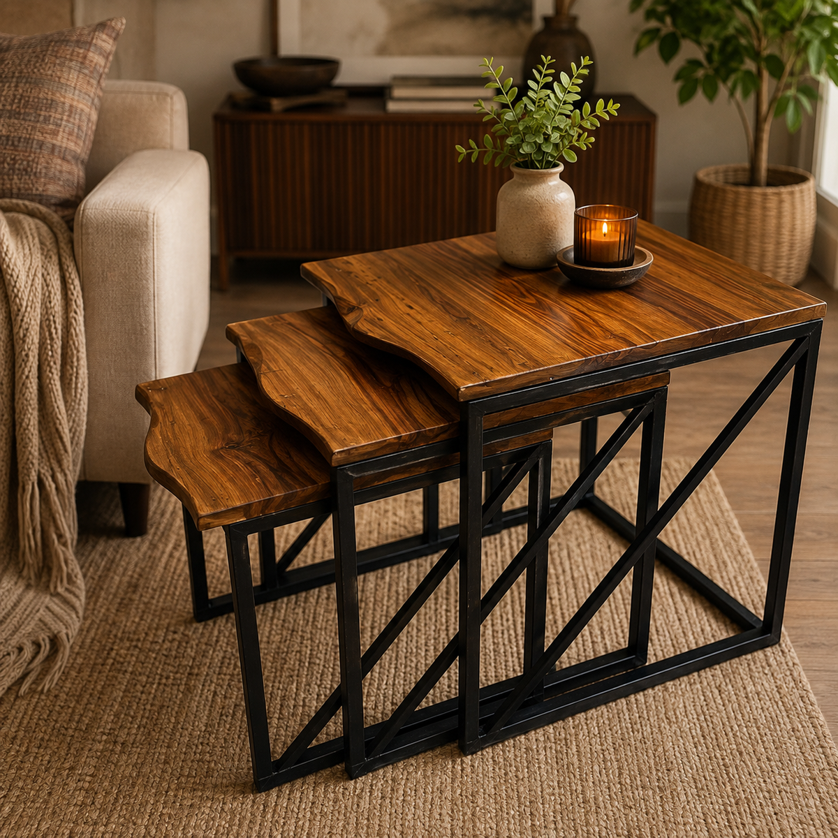 Three nested square nesting tables with warm medium-brown wood tops and black metal crisscross frames, styled in a cozy living room setting.